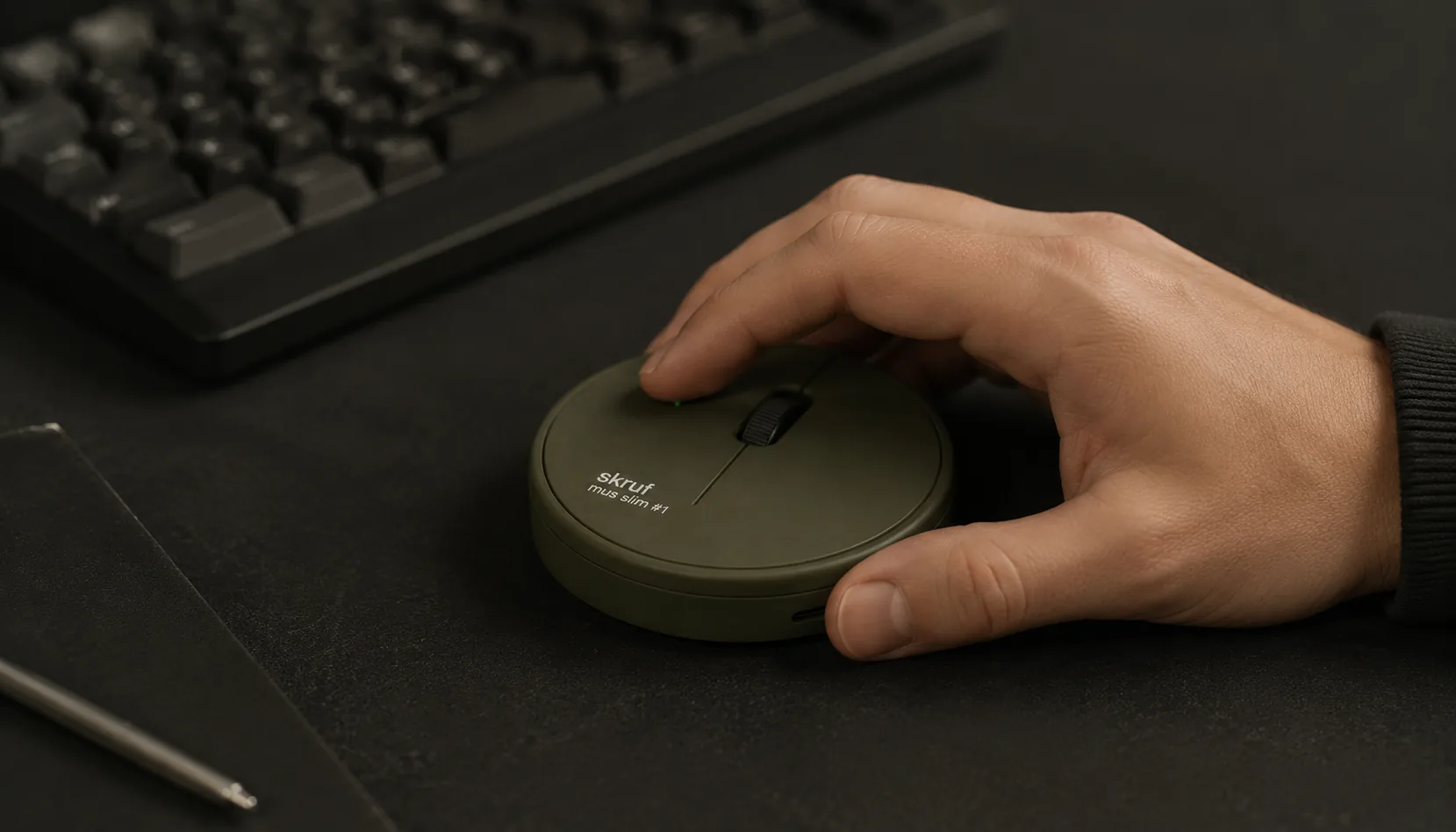 Musen i bruk på et mørkt skrivebord med mekanisk tastatur i bakgrunnen